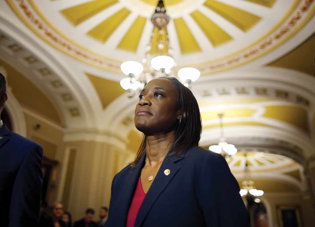 Sen. Laphonza Butler in a blue blazer stands in the portico of a government building