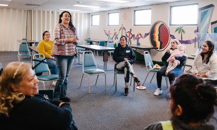 A woman speaking to her peers in a group