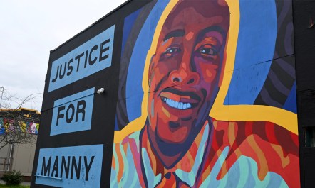 A colorful mural in Tacoma, Washington, honors Manuel Ellis, who was killed by Tacoma Police in 2020. Text on the mural, alongside a painted portrait of Ellis's face, reads "Justice for Manny."